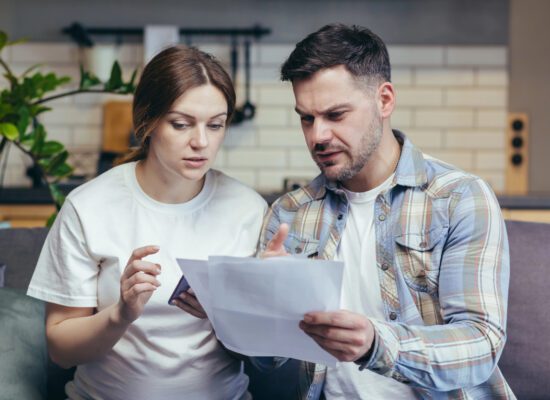 Person reviewing a letter notifying them that their long-term disability benefits have been terminated after 24 months, illustrating the transition to the "any occupation" test.